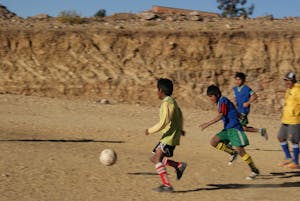 boys playing soccer on rustic soccer field