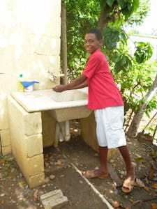 Adalberto washes his hands at his clean water faucet. This clean water has led to a healthier life for Aldalberto and his family.