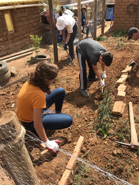 The team worked with community members to fence and plant a garden.