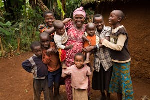 Mother in the Democratic Republic of Congo smiles next to her large family of children