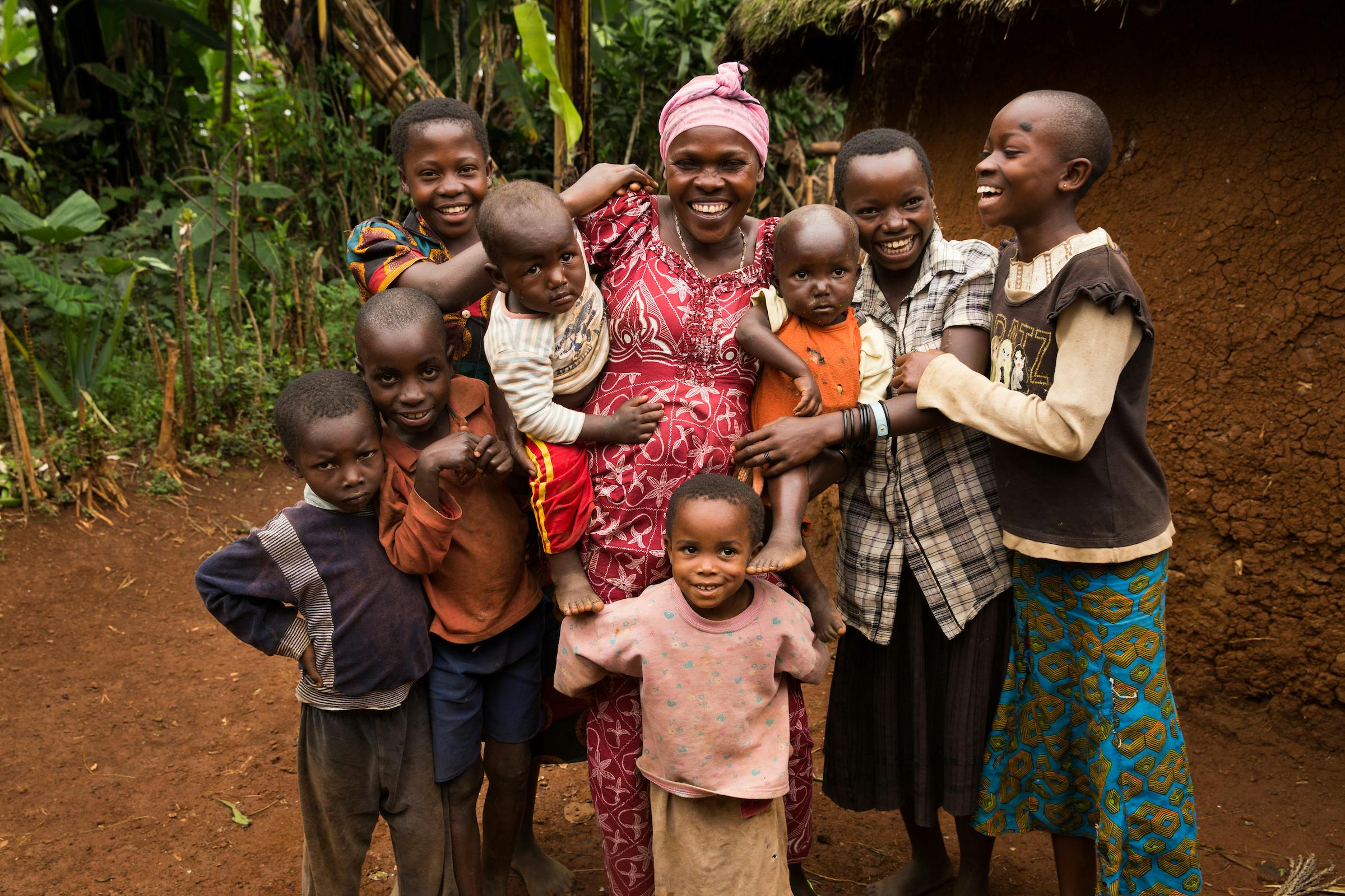 International Womens Day Photoessay - Mother in the Democratic Republic of Congo smiles next to her large family of children