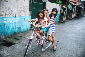 Girls riding a bike in the Philippines