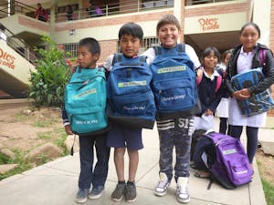 School children in Bolivia pose with their new backpacks and school supplies. 