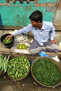 Bangladeshi man sells green vegetables in the market