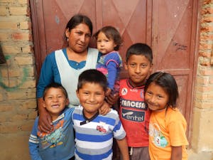 Bolivian family with mother and five children standing outside house