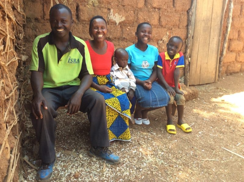 Man with wife and children in their home in Burundi
