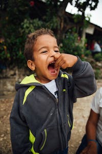 Young boy opens his mouth to eat a vitamin