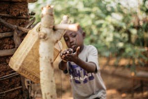 Little boy washes his hands in Burundi from a "tippy tap" with a jerrycan.