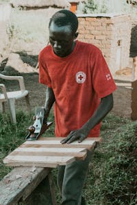 Peter works on a piece of furniture at his carpentry shop in Uganda.