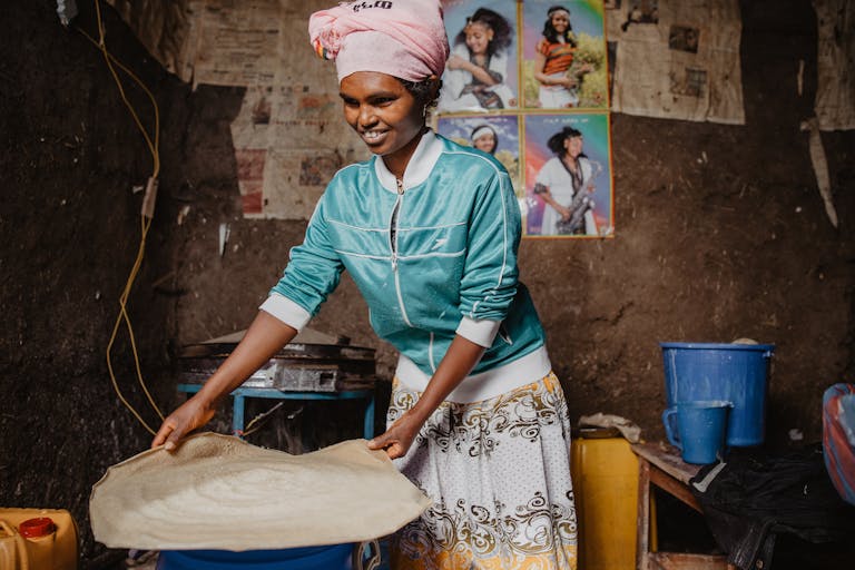 Sintayehu, who was an orphan, bakes injera bread for her business in Ethiopia.