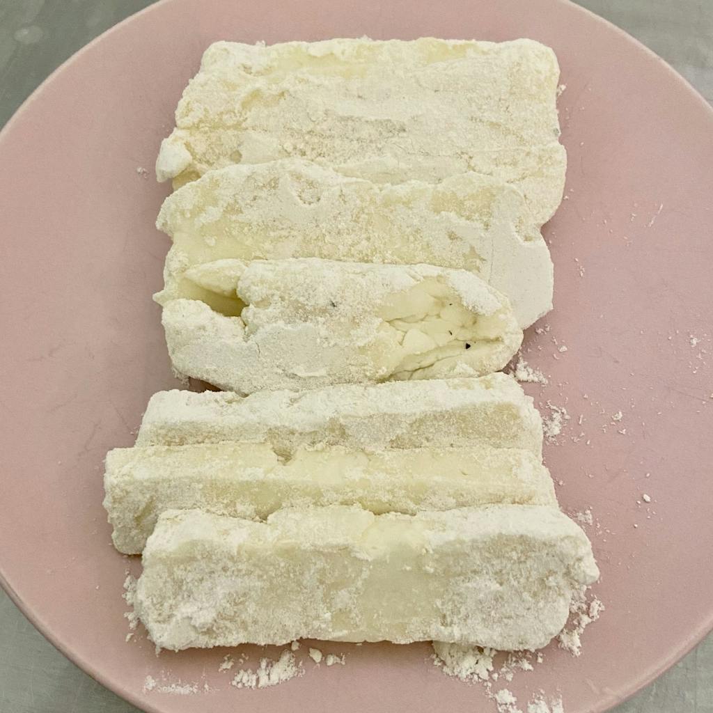 frying cheese covered in flour on a plate