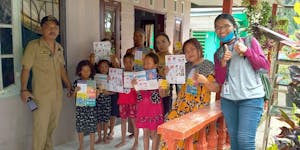 Children holding their COVID-19 education flyers