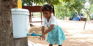 Young girl washing her hands.