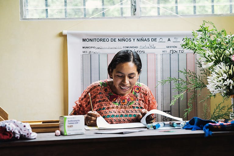guatemalan woman seated at desk reading