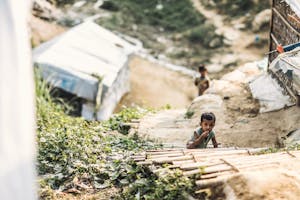 Young child climbing outdoor stairs in Rohingya refugee camp