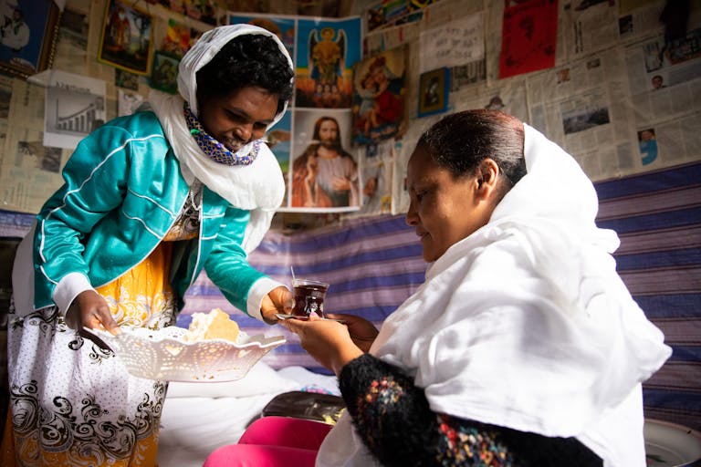two ethiopian women sharing a cup of coffee