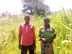 Ildephonse Kasinda, left, was embroiled in a disagreement with his neighbor for more than two years regarding an irrigation diversion that was causing his crops to die. He proposed a solution that he learned about in a play. Now he, his neighbor, and their wives word togethr to assure success for all. Pictured with Ildephonse is his neighbor's wife.