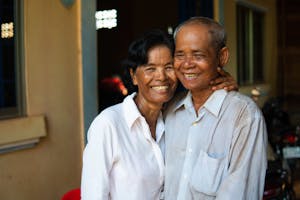 man and woman in white shirts smiling and hugging