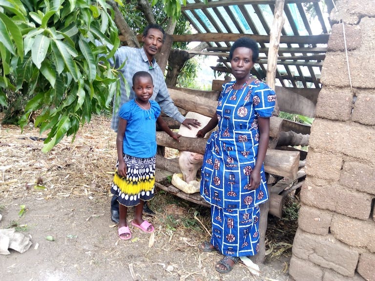 Bermadette's famlly outside pig sty with adult pig