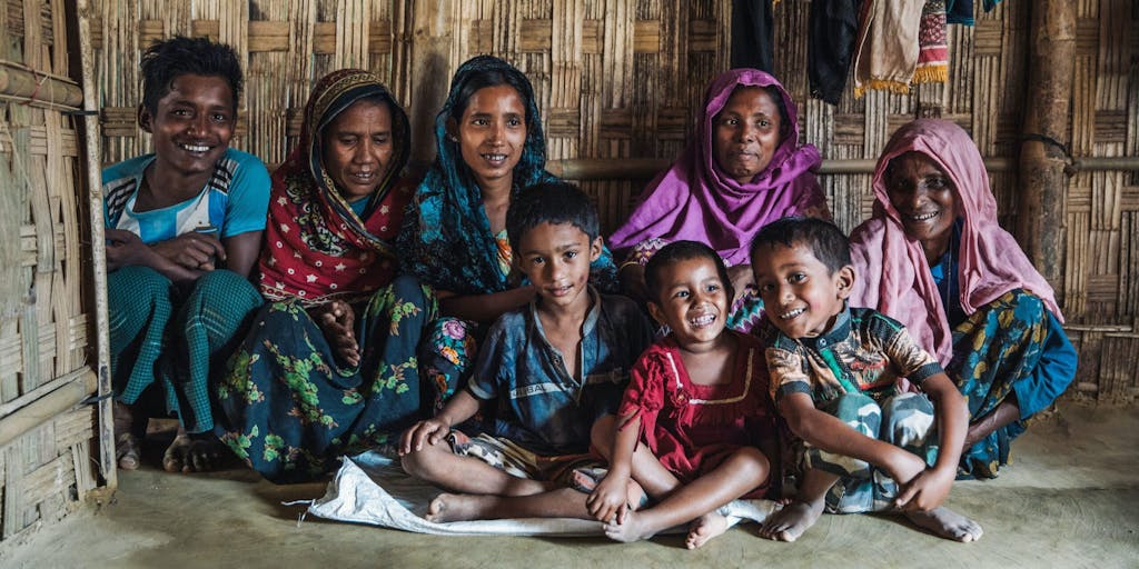 Rohingya refugee families sit inside a home in Bangladesh