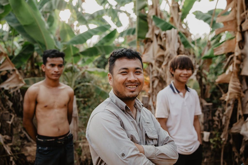 men in Cambodia posing outside banana trees