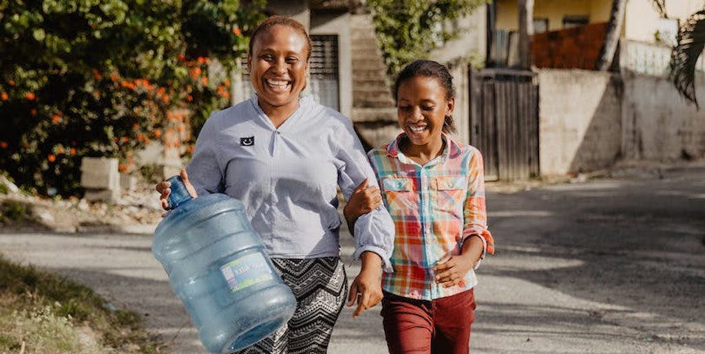 Anianna and her mother getting a water jug refilled together