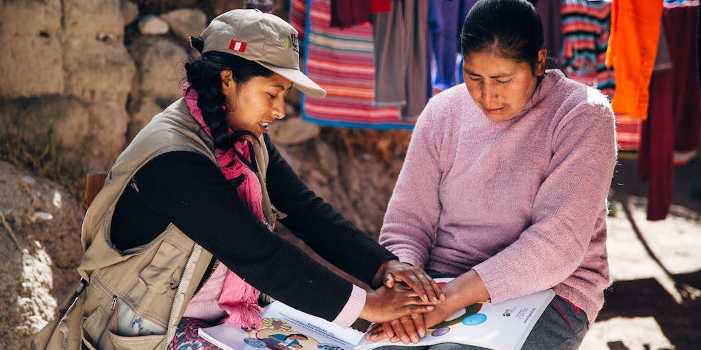 Two women praying in Peru