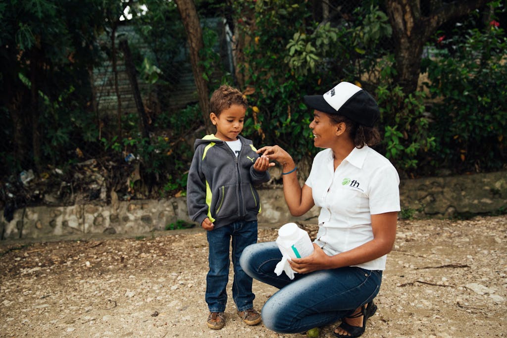 FH staff member gives deworming pill to young boy in the Dominican Republic.