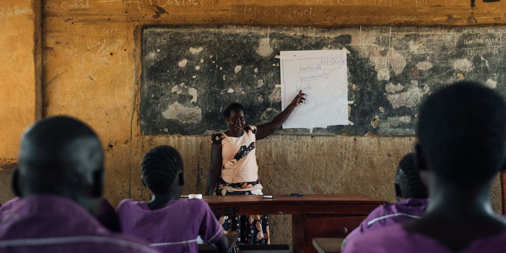 An FH leader teaches young girls in Uganda about womens health and hygiene