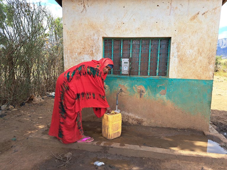 Kule utilizes the new water meter a close walking distance from her home.