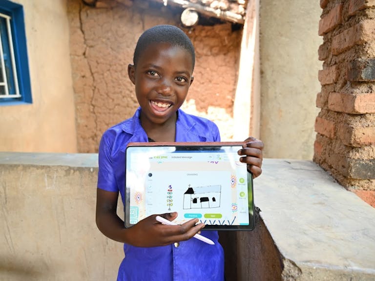 child holds up personalized christmas card from his FH sponsor